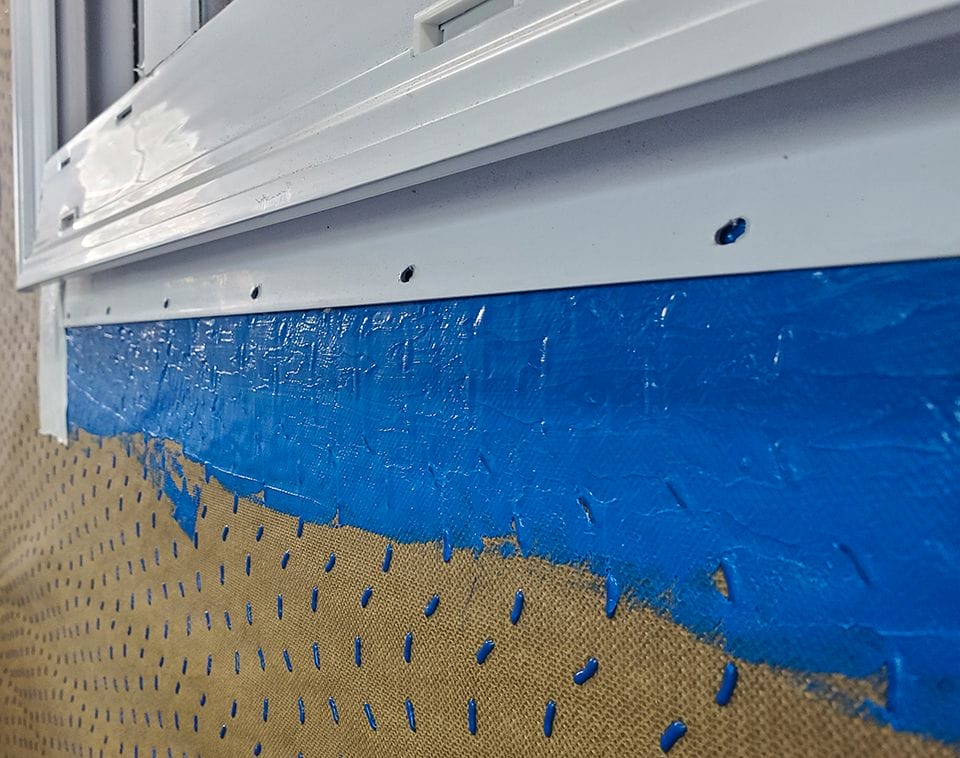 Detail shot of blue HydroFlash LA smoothed on exterior window flashing detail