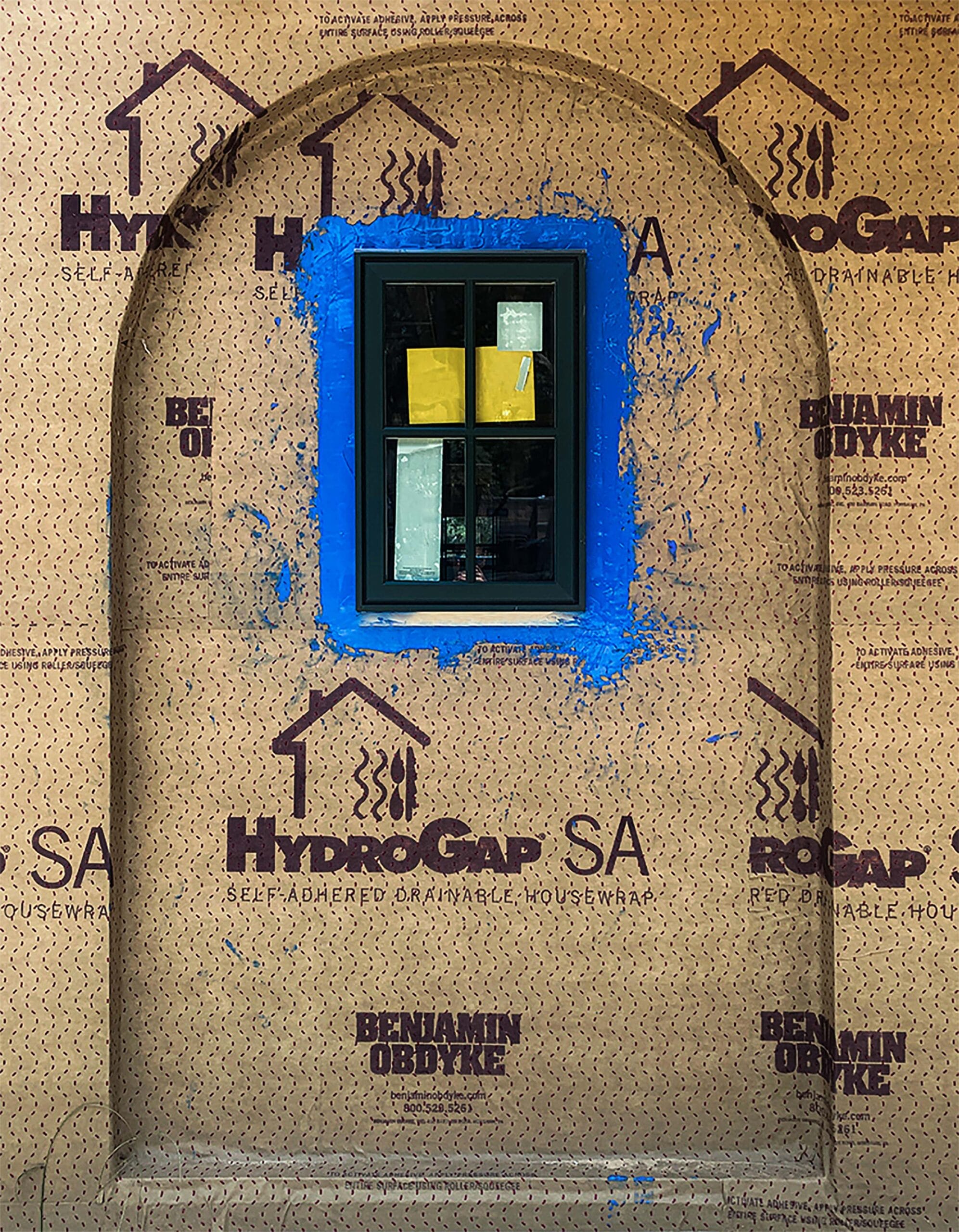 Installation of HydrpGap SA self-adhered drainable housewrap with HydroFlash LA liquid-applied window flashing.