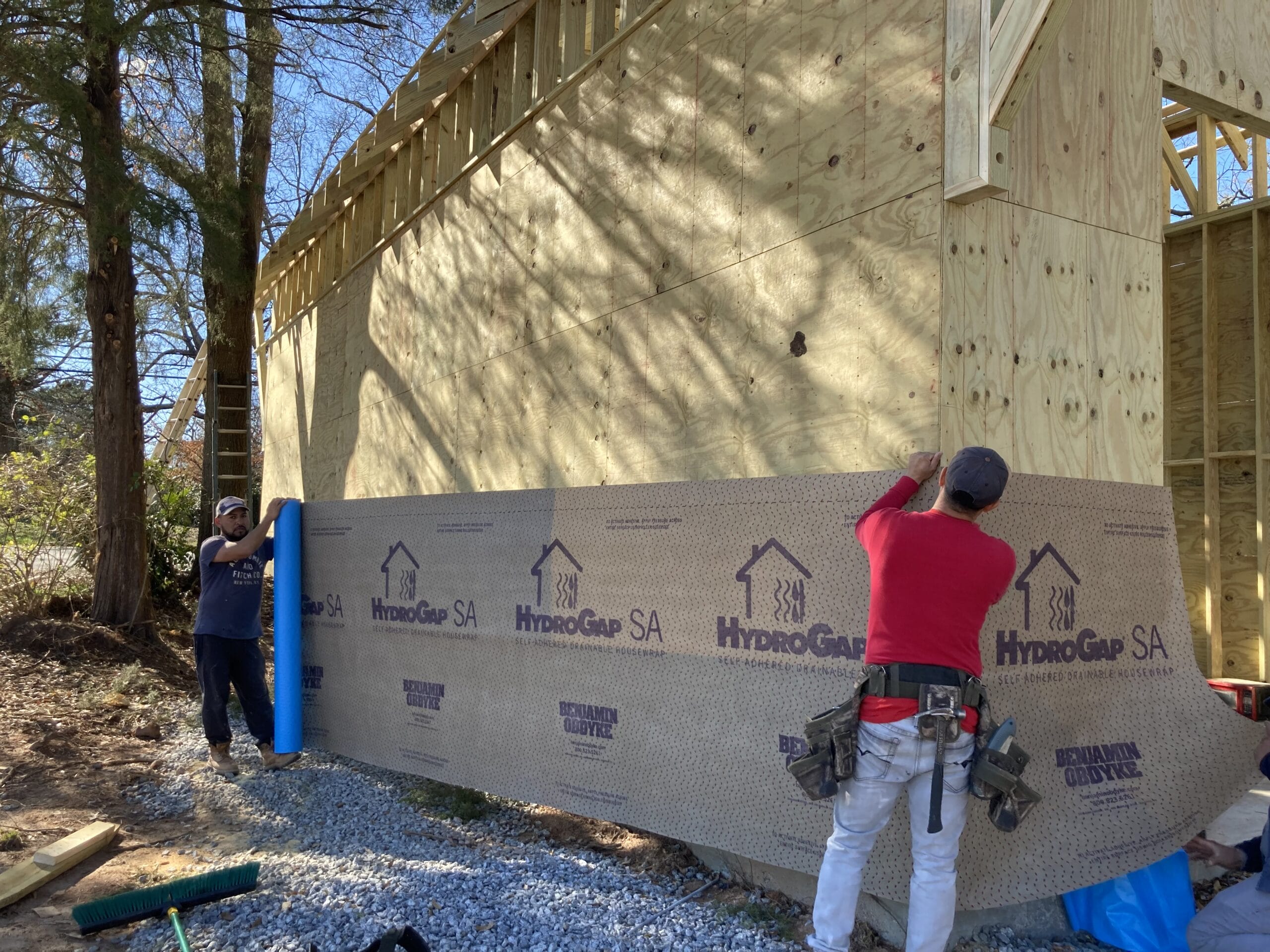 Installation of HydroGap SA self-adhered drainable housewrap on exterior sheathing.