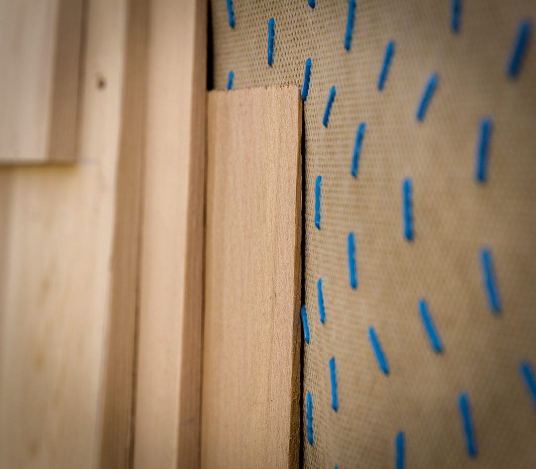 Up close image of HydroGap drainable housewrap layered behind wood siding.